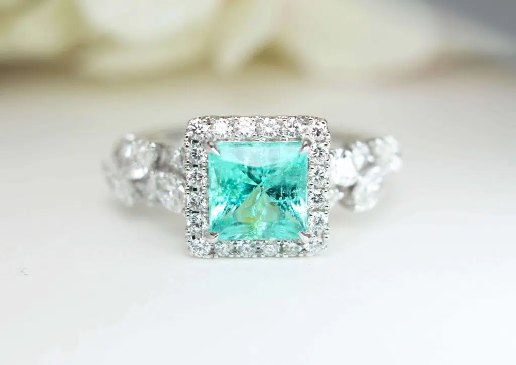 Princess-cut Paraiba tourmaline engagement ring with a round diamond halo and marquise diamond shoulders, GIOIA bespoke Singapore