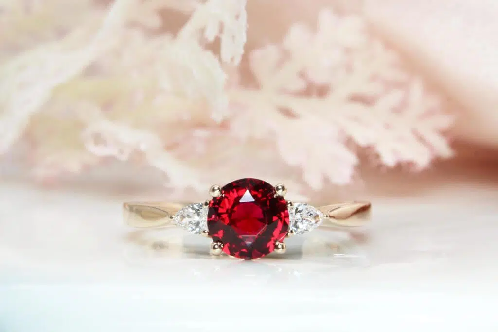 Vivid Red Spinel Proposal Ring - Unique gemstone engagement ring design with side pear diamond in rose gold.