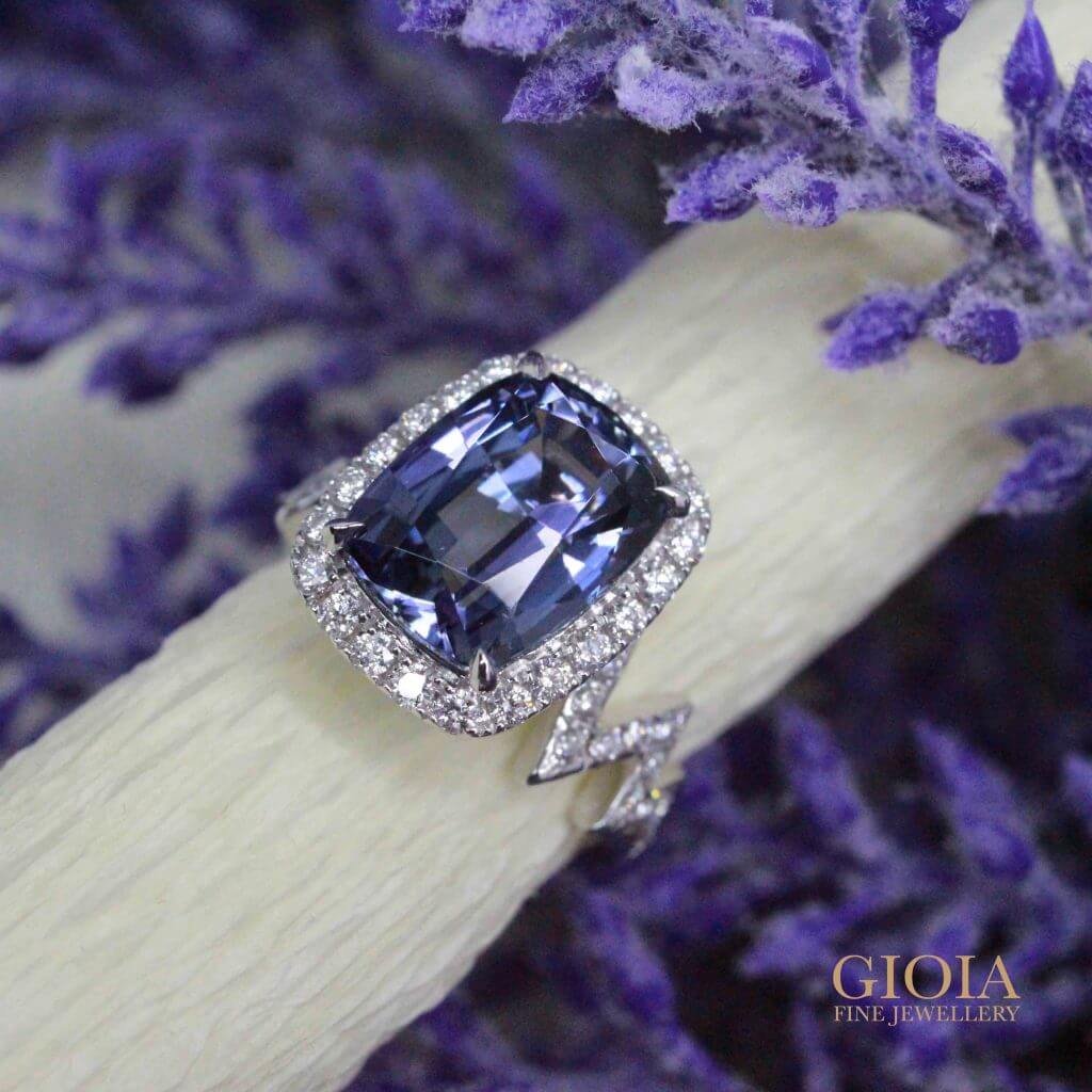 A 4.39ct cushion unheated tanzanite engagement ring with a round diamond halo and zig-zag band in 18K white gold, GIOIA Singapore