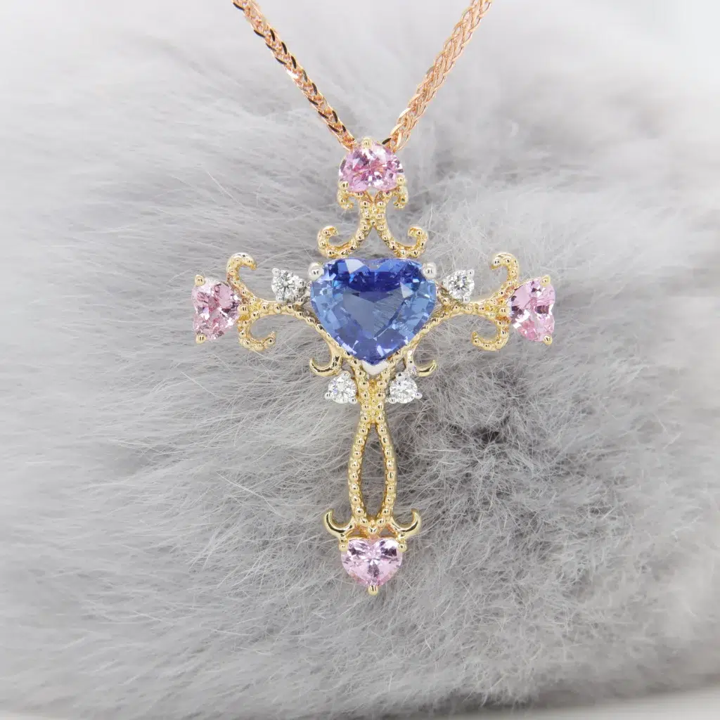 Heart-shaped blue sapphire cross pendant in vintage milgrain yellow gold with pink sapphire hearts, GIOIA bespoke Singapore