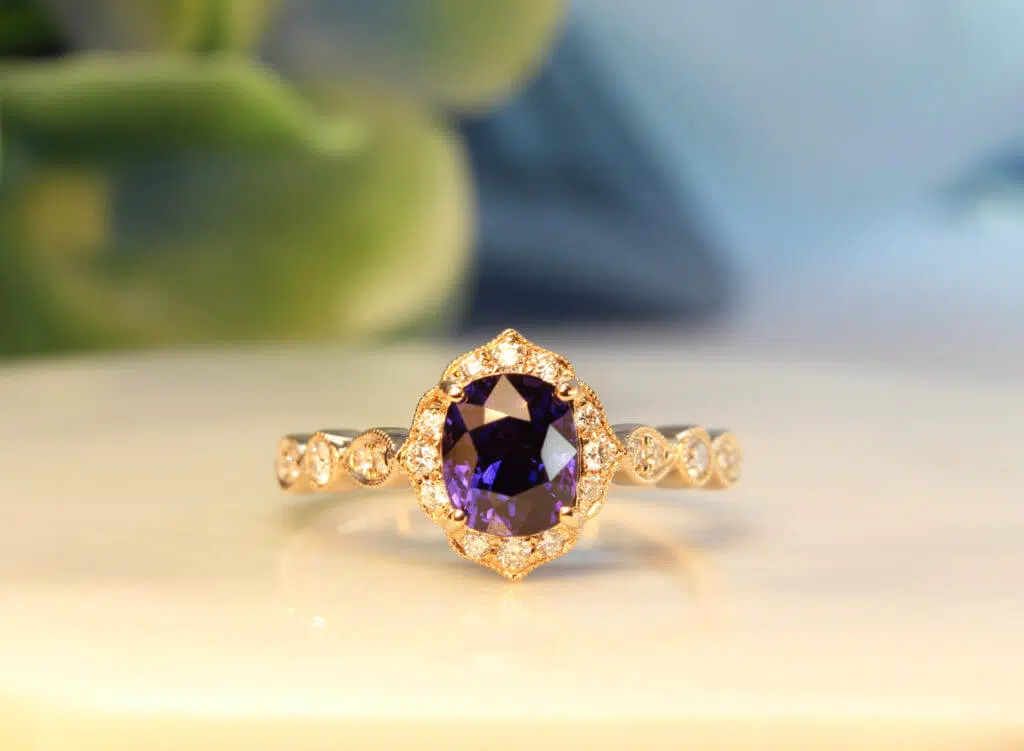 Art deco Proposal Ring with colour change sapphire, surrounded with diamonds to impart a floral and feminine look to this design. This design exudes an overall vintage art deco look with its mil-grain design | Local Singapore Private Jeweller in customised proposal ring.
