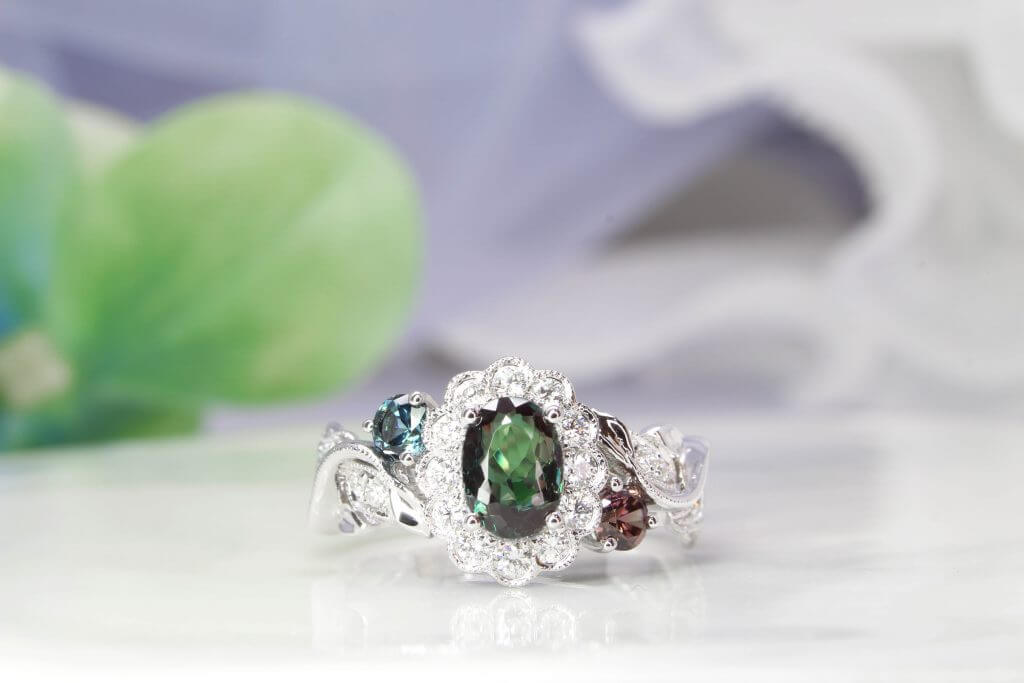 Alexandrite gem appears green under daylight and reddish-purple under incandescent light, colour change phenomenon. Customised flora ring with halo diamonds set around the alexandrite, resemble a flower design. Customised Jewellery with colour change alexandrite jewellery in Singapore