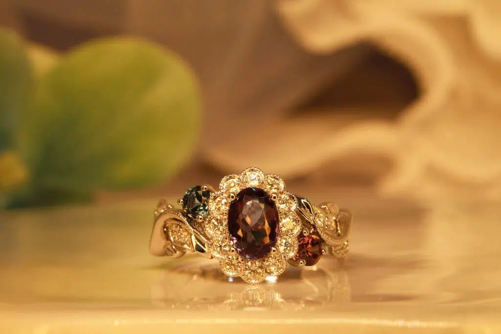 Alexandrite gem appears green under daylight and reddish-purple under incandescent light, colour change phenomenon. Customised flora ring with halo diamonds set around the alexandrite, resemble a flower design. Customised Jewellery with colour change alexandrite jewellery in Singapore