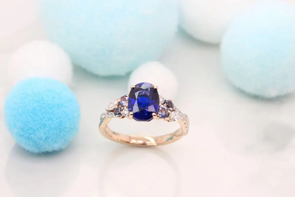 Customised Gemstone Engagement Ring Featuring a vivid blue sapphire gem with cluster blue spinel