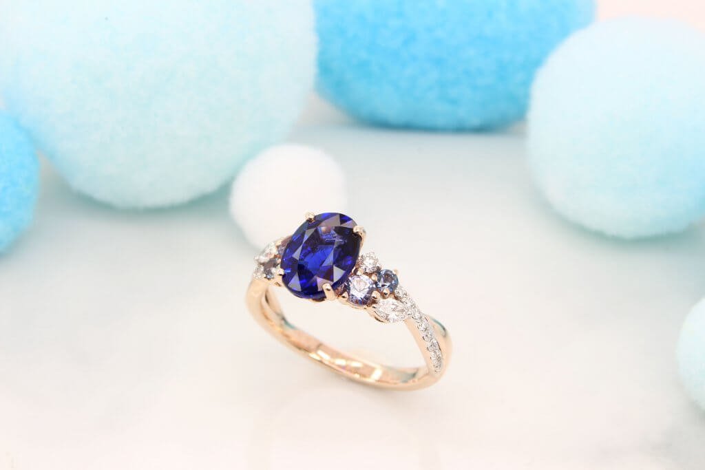Featuring a vivid blue sapphire gem with cluster blue spinel and marquise shaped diamond design. Exceptional Sapphire engagement ring customised unique design.