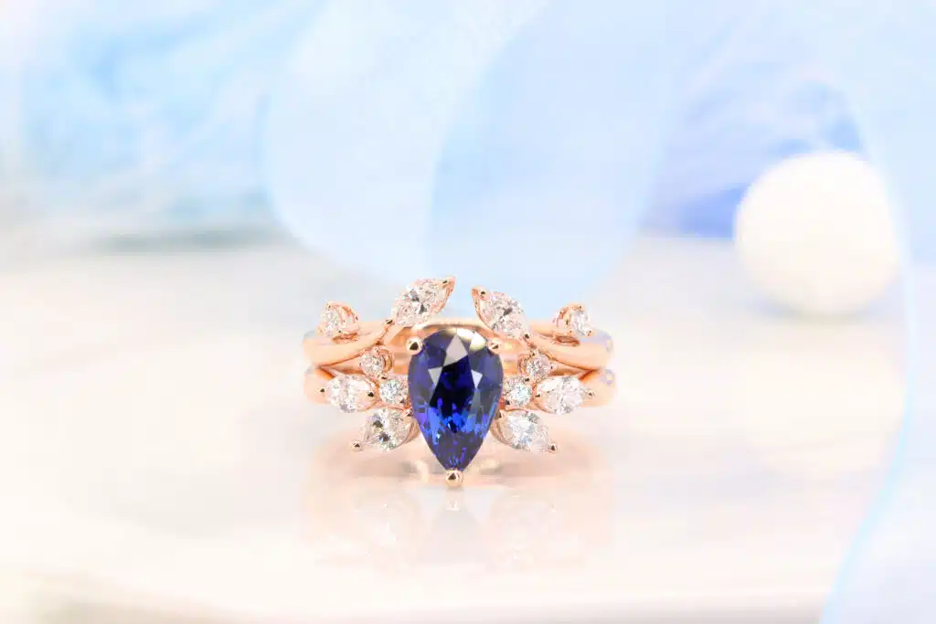 Blue Sapphire Engagement Ring with Floral diamond Design customised blue sapphire ring in rose gold with side marquise diamond.