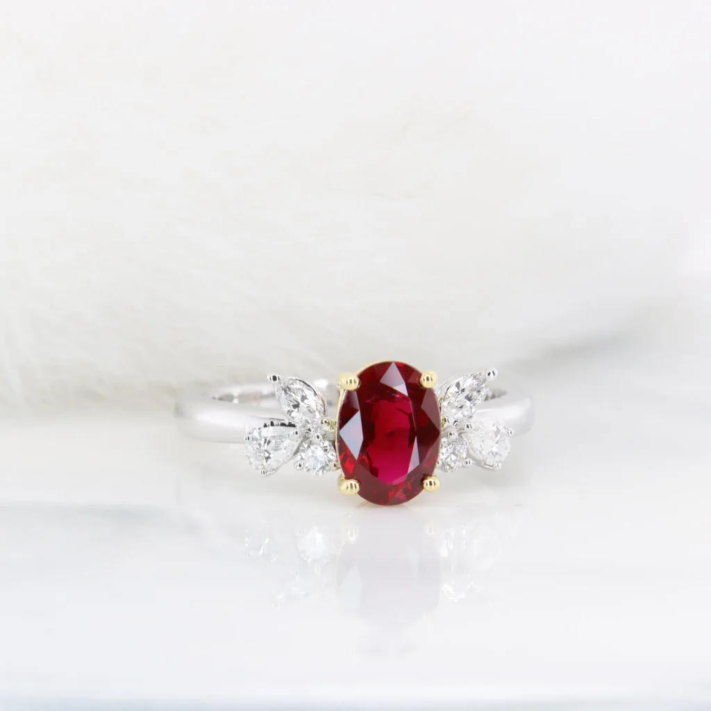 Burma ruby ring with a 0.83ct oval pigeon blood ruby in yellow gold claws and marquise, pear and round diamonds on each shoulder