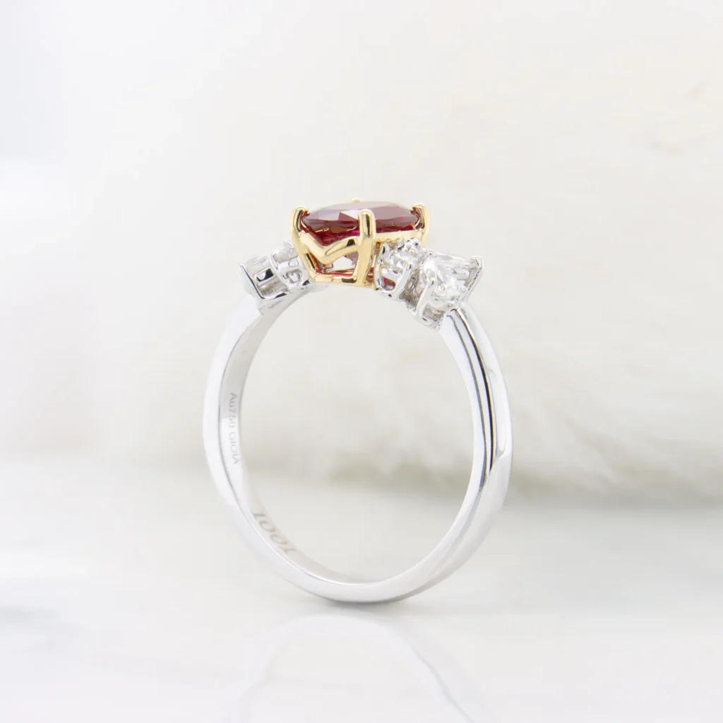 Side view of the Burma ruby ring showing the yellow gold basket under the ruby and the white gold band