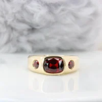 Red spinel signet ring in yellow gold, a cushion-cut spinel bezel-set between two round red accent stones, GIOIA bespoke jewellery Singapore